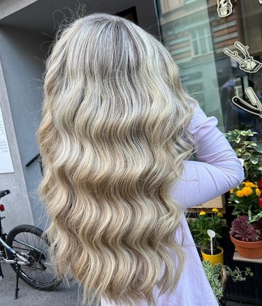 Auf dem Bild sieht man das Rückenansicht eines Mädchens mit einer wunderschön gemachten Balayage-Frisur.