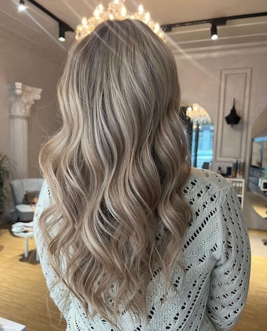 Auf dem Bild sieht man das Rückenansicht eines Mädchens mit einer wunderschön gemachten Balayage-Frisur.